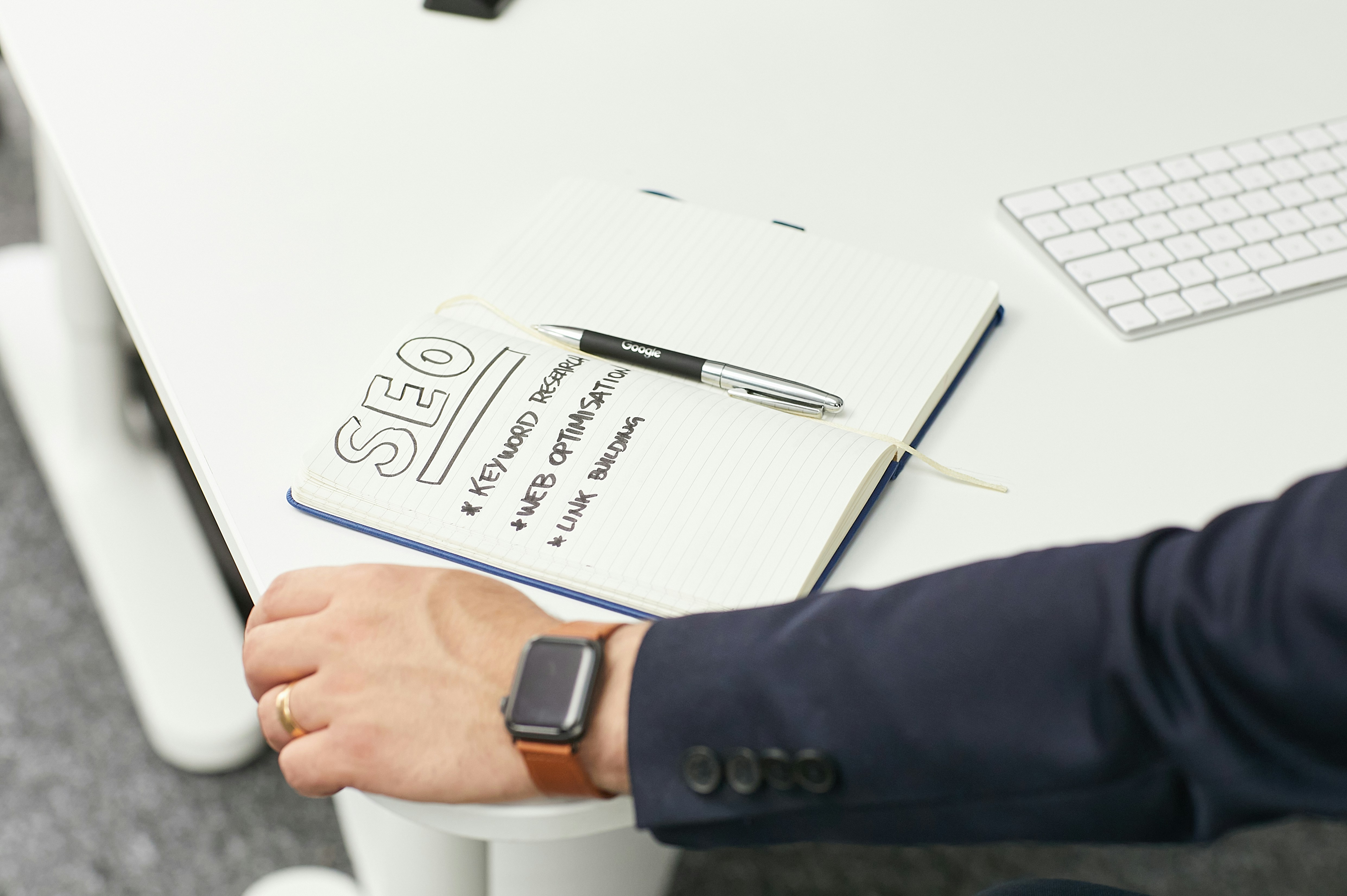 arm with a watch and notebook and a pen